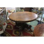 An early 20th century extending Oak Oval dining table, with carving detail around the top edge and a