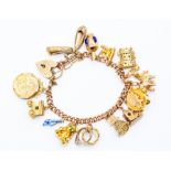 A 9ct gold charm bracelet with various 9ct gold and unmarked yellow metal charms,  including