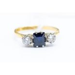 A sapphire and diamond ring, the centrally set rectangular cut sapphire with diamonds set either