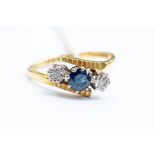 A three stone sapphire and diamond ring, central round cut sapphire, two illusion set diamonds