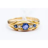 A sapphire and diamond 18ct gold boat ring, set with three graduated round cut sapphires, two