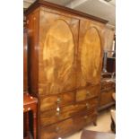 A Regency mahogany linen press, circa 1810, moulded cornice, two oval panelled doors opening to