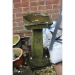 An 18th Century limestone bird bath on plinth, square tapered top with circular inlay, reversed