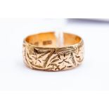 A 9ct gold Victorian wedding band, embossed ivory leaf decoration, width approx 8 mm, size O,