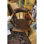 An oak leather seated captains chair.