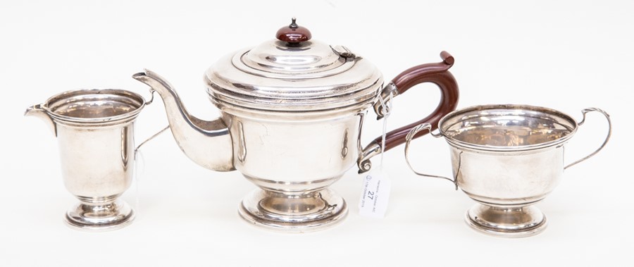 A George VI three piece plain silver tea set comprising teapot, sugar bowl and milk jug, the