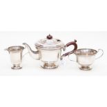 A George VI three piece plain silver tea set comprising teapot, sugar bowl and milk jug, the