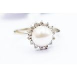 A pearl cluster ring, set with a round cultured pearl, pink tone,  size approx. 8mm, with a white