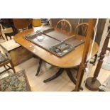 An extending dining table in the Georgian style, on tripod sabre legs with claw metal feet and brass