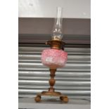 Late 19th Century oil lamp with pink vaseline glass centre, grade design on brass stand