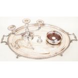 An oval plated serving tray, silver wine coaster, candle holder and plated cake slice