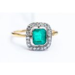 An emerald and diamond Art Deco ring, the central emerald cut emerald measuing approx 5mm x 7mm,