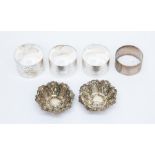 Four silver Birmingham napkin rings and a pair of Chester silver pin trays