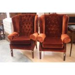 Two button back wing chairs covered in orange velvet. Square legs with slight taper.