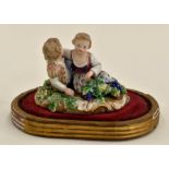 A Meissen figure of two young children on stand with grapevine