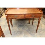 A late Victorian table in oak with brass handles, decorative carving and square tapered supports