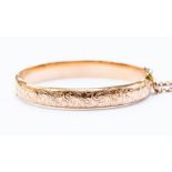 A 9ct rose gold bangle, hinged, scroll and foliate engraved decoration, internal diameter approx.
