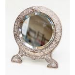 A late Victorian silver mounted free standing mirror, embossed floral leafage scrolls and with easel