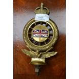 An early cast brass RAC badge, inset with an enamel Union Jack flag, surmounted by a coronet