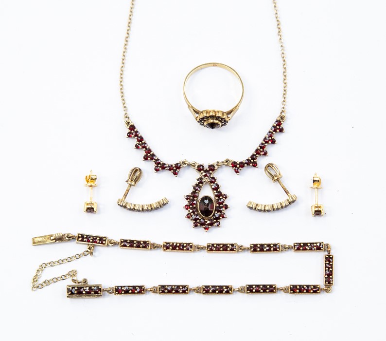 A 15ct garnet set suite comprising a ring, bracelet, necklace and two pairs of earrings, (5)