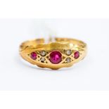 A Victorian ruby and diamond 18ct gold ring, three round cut rubies set with diamond accents in