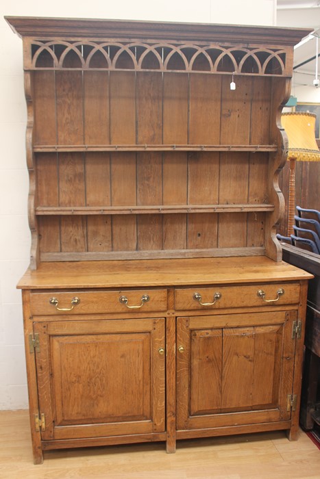 A  20th Century oak dresser and plate rack. The base having two drawers with brass handles and two