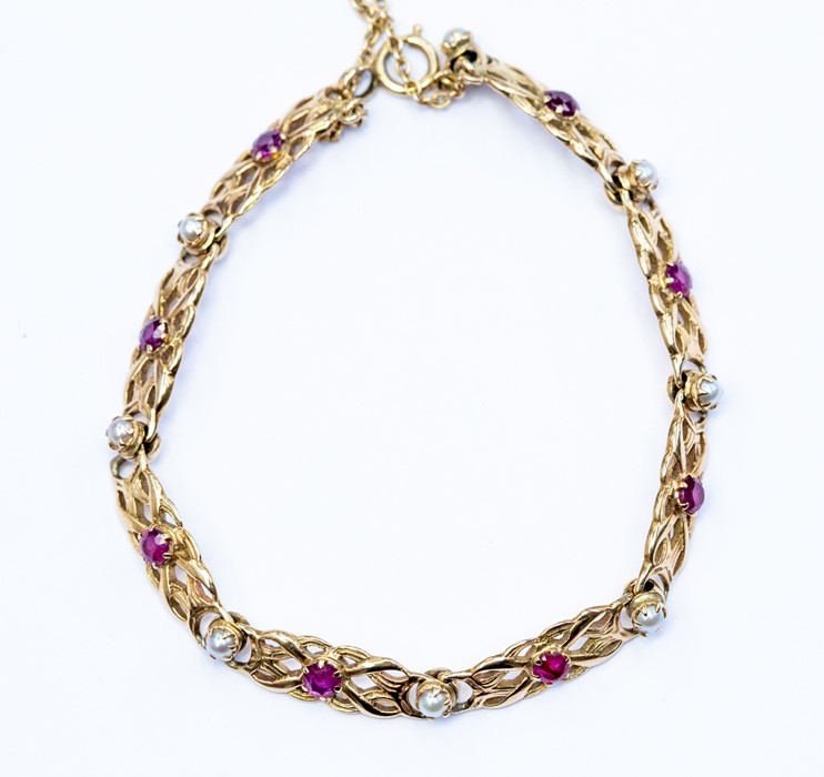 A ruby and pearl 9ct gold fancy-link bracelet, comprising pierced 9ct gold links set to the centre
