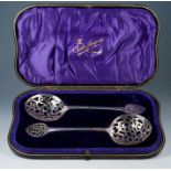 A pair of Arts & Crafts silver sifting spoons, heart shaped openwork terminals with similar openwork