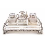 An Edwardian large silver mounted rectangular inkstand, the plain body with pen wells and border