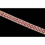 A ruby and diamond set 14ct yellow gold bracelet, twenty-two links comprising a central row of