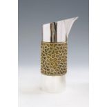 Stuart Devlin: A modern silver and parcel gilt jug, plain body with central raised filigree