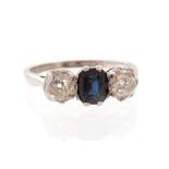 A sapphire and diamond three-stone platinum ring, central octagonal step-cut blue sapphire approx