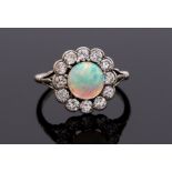 An Art Deco opal and diamond ring, the round cabochon opal set centrally with a milled border of old