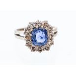 A sapphire and diamond cushion shaped cluster 18ct white gold ring, the central cushion cut sapphire