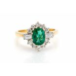 An emerald and diamond oval cluster 18ct gold ring, the central oval mixed cut emerald approx 8mm