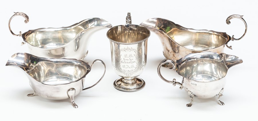 A pair of George V silver oval sauceboats, wavy rim on three hoof feet, with C-scroll handle, leaf