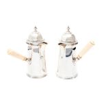 A matched pair of George V silver coffee pots, plain tapering octagonal bodies with hinged domed