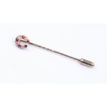 A ruby and diamond horseshoe stick pin, assessed as approx 9ct, total gross weight approx 1.7gms