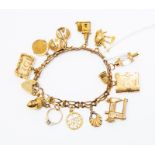 A 1950s 9ct gold charm bracelet with thirteen charms including shell, acorn, book, church, market,