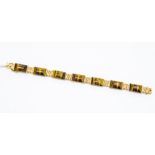 A 9ct gold and tigers eye bracelet with textured links and polished rectangular cabochons (one is