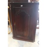 A George III oak wall hanging corner cupboard, circa 1800, single door fitted opening to three