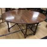 A mid 18th century and later gateleg oval dropleaf dining table above a single drawer with a brass
