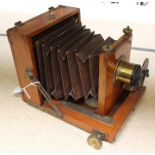 A wooden and brass, quarter plate camera, complete with lens