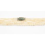 A triple strand cultured pearl necklace, the white metal clasp set turquoise and rose cut diamonds