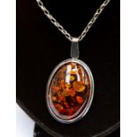 A sterling silver pendant on chain, set Baltic amber