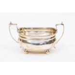 A George V silver sugar bowl with twin handles and on bun feet, by Thomas Edward Atkins, Birmingham,