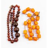 A cherry coloured bead necklace along with a butterscotch coloured bead necklace