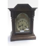 An Edwardian oak bracket clock with silvered face and gilt metal spandrels (key and pendulum)