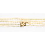 A double string of cultured pearls, both united with a 9ct gold clasp, set with a daisy head setting