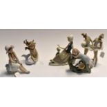 Lladro figurines, a reclining girl with dove, a pair of practising ballerinas, a girl looking at a